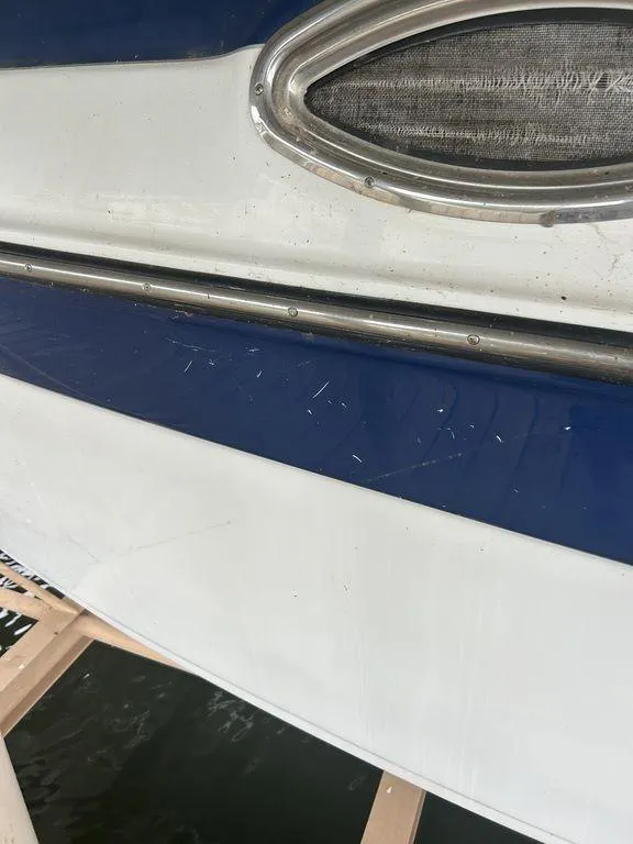 Slide: The Image of Close-up of 2003 Crownline 270 BR boat exterior with blue and white detailing. - 6
