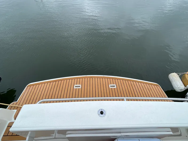 Slide: The Image of 2007 Silverton 330 Sport Bridge swim platform with teak decking on calm water. - 10