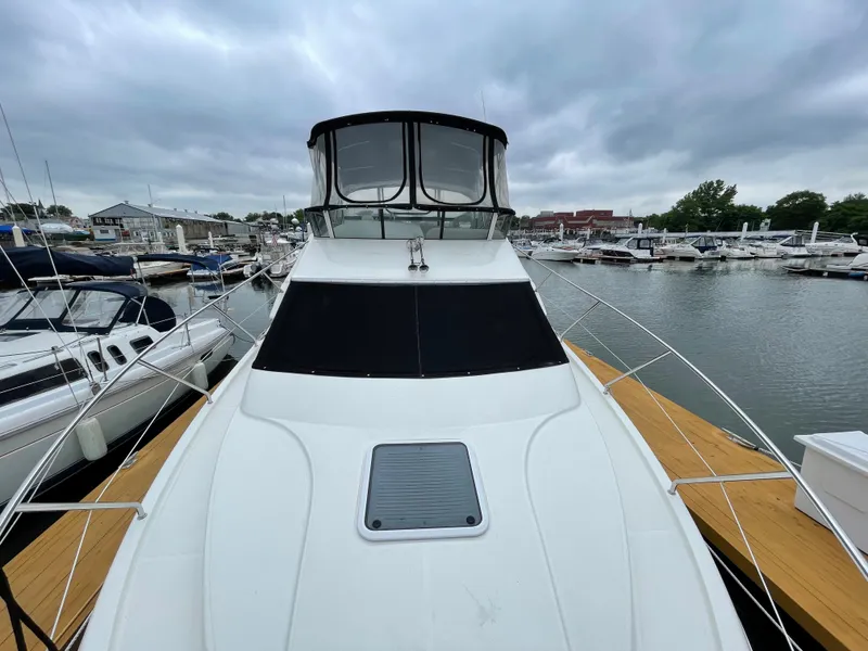 Slide: The Image of 2007 Silverton 330 Sport Bridge yacht docked at a marina under cloudy skies. - 11