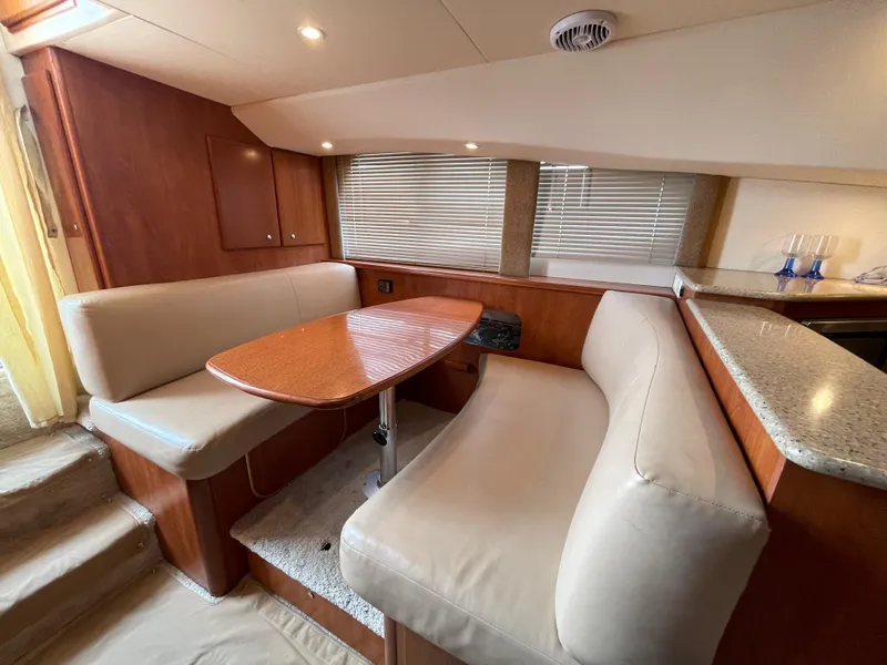Slide: The Image of 2007 Silverton 330 Sport Bridge interior with dining area and beige seating. - 13