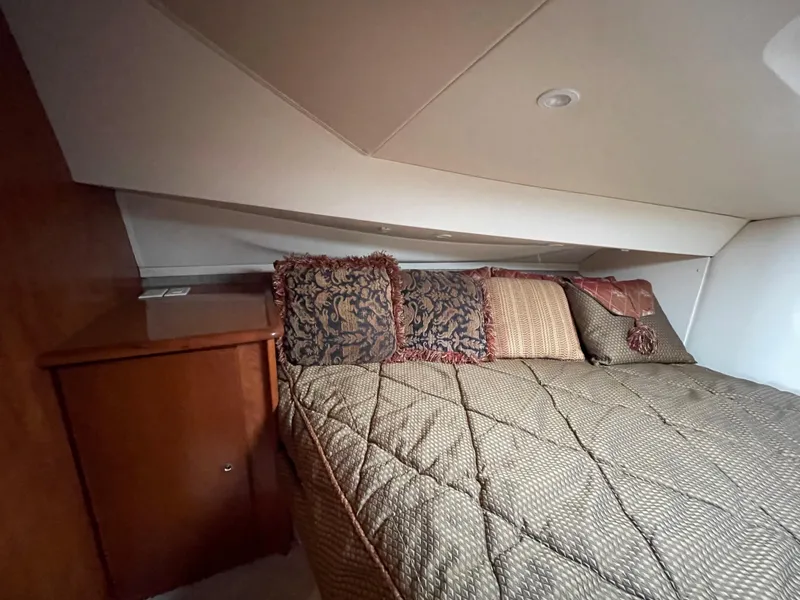 Slide: The Image of 2007 Silverton 330 Sport Bridge cabin with cozy bed and decorative pillows. - 16