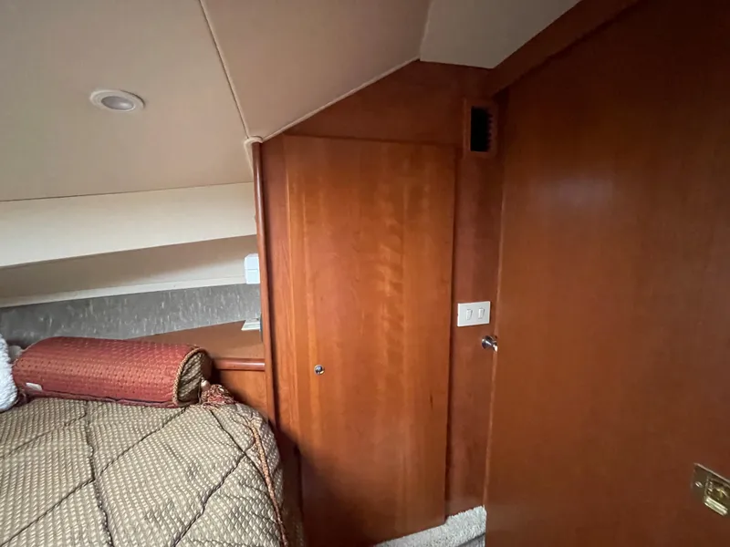 Slide: The Image of 2007 Silverton 330 Sport Bridge cabin interior with wooden door and cozy bedding. - 17