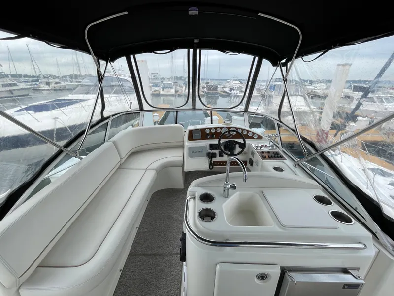 Slide: The Image of 2007 Silverton 330 Sport Bridge interior with helm, seating, and marina view. - 5