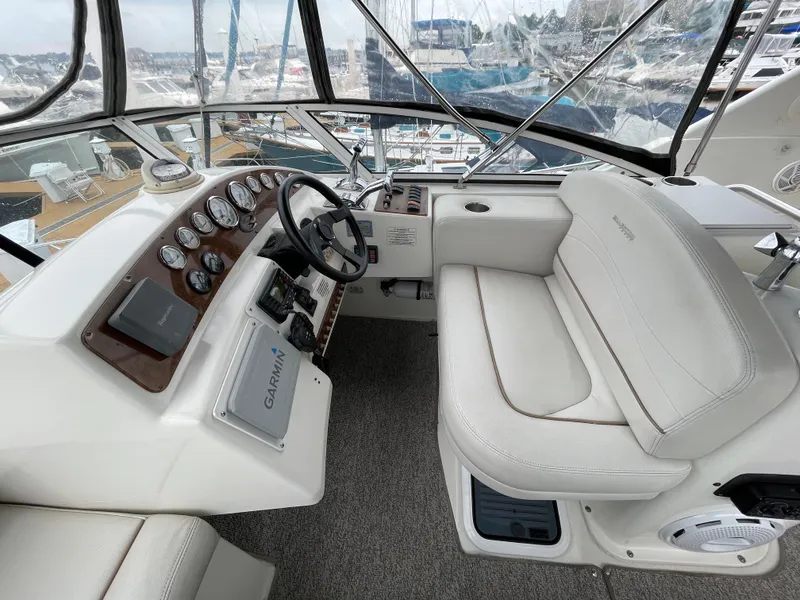 Slide: The Image of 2007 Silverton 330 Sport Bridge helm with white seating and navigation controls. - 6