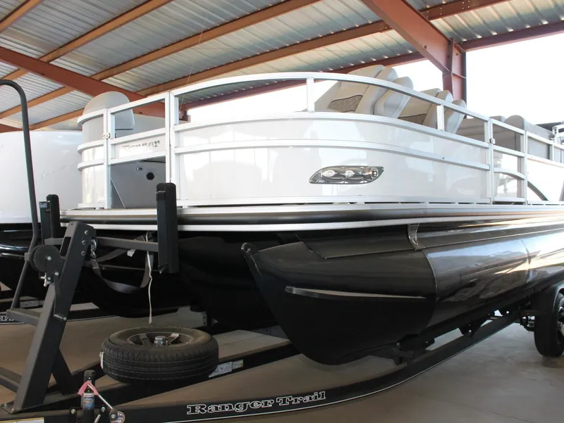 Slide: The Image of 2025 Ranger RP223FC pontoon boat on trailer in covered storage. - 10