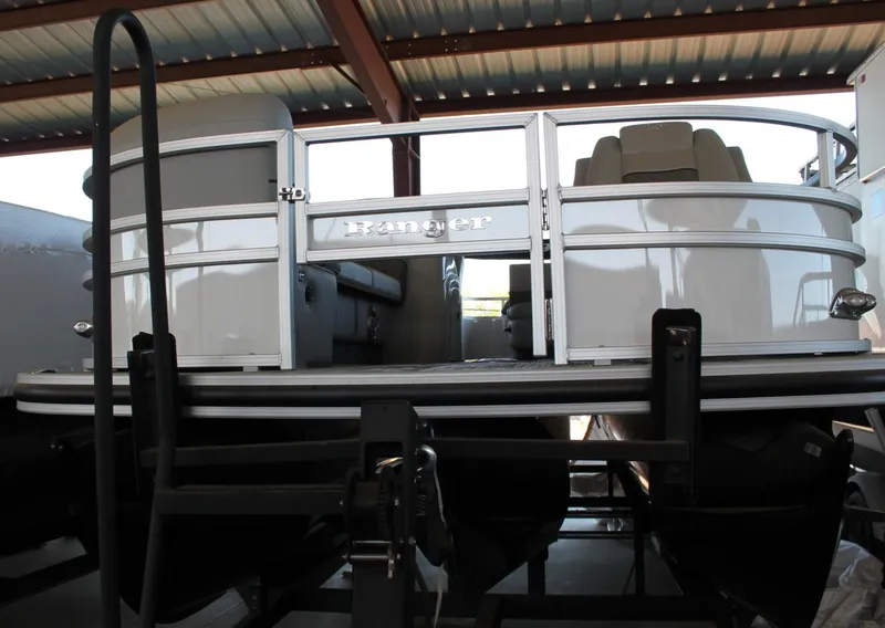 Slide: The Image of 2025 Ranger RP223FC pontoon boat under a metal roof, showcasing its sleek design. - 2