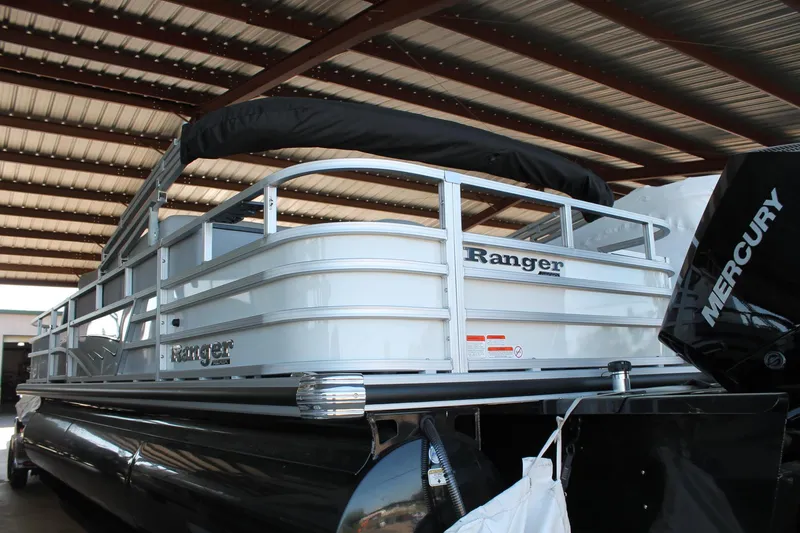 Slide: The Image of 2025 Ranger RP223FC pontoon boat with Mercury engine under a metal roof. - 5