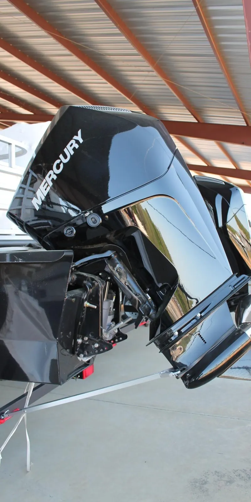 Slide: The Image of 2025 Ranger RP223FC boat with Mercury outboard motor under a metal roof. - 6