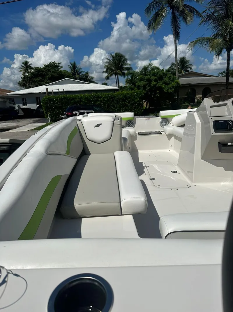 Slide: The Image of 2022 Starcraft SVX 191 OB boat with white and green seating, under a sunny sky. - 19