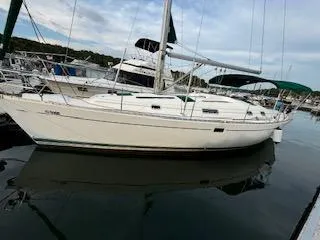 Slide: The Image of 1998 Beneteau 381 sailboat docked in a marina, calm waters, overcast sky. - 42