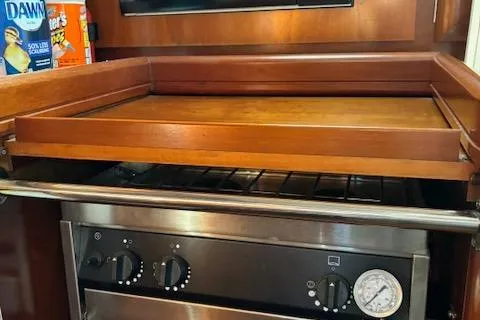 Slide: The Image of 1998 Beneteau 381 yacht kitchen with stove, wooden countertop, and cleaning supplies. - 45