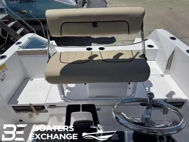 Slide: The Image of 2025 Yamaha Boats 222 FSH Sport helm with beige seating and steering wheel, Boaters Exchange logo. - 3