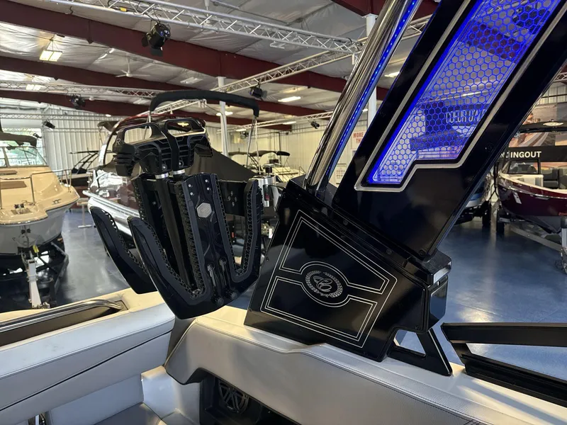 Slide: The Image of 2025 Cobalt R4 Surf boat interior with illuminated blue accents in showroom. - 16