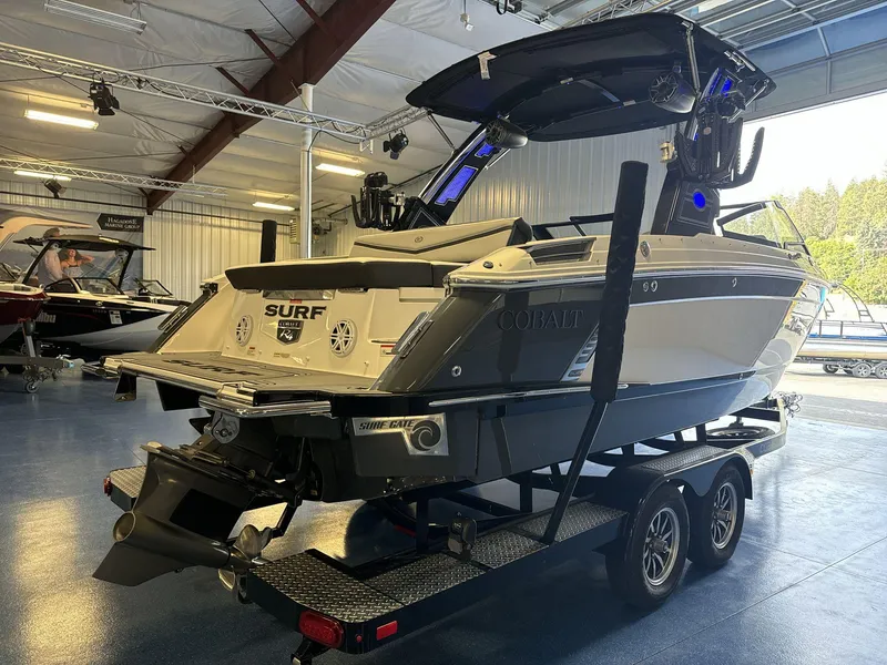 Slide: The Image of 2025 Cobalt R4 Surf boat on trailer in showroom, rear view. - 7