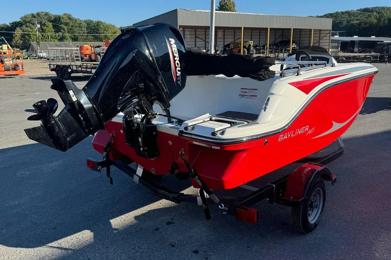 Slide: The Image of 2025 Bayliner 15E boat with Mercury outboard motor, red and white design, on trailer. - 2