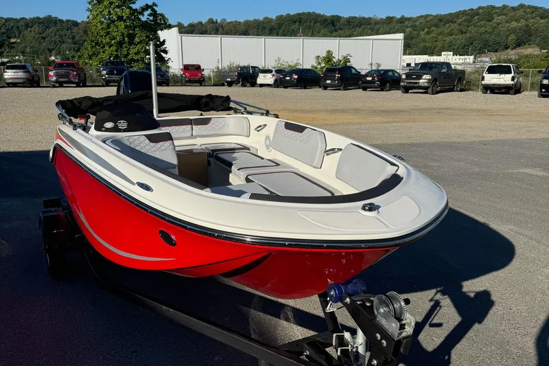 Slide: The Image of 2025 Bayliner 15E boat with red hull on trailer in parking lot. - 4