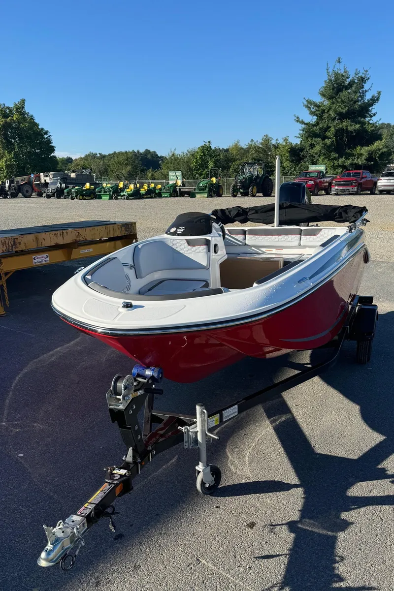 Slide: The Image of 2025 Bayliner 15E boat on trailer, red and white, parked outdoors. - 9