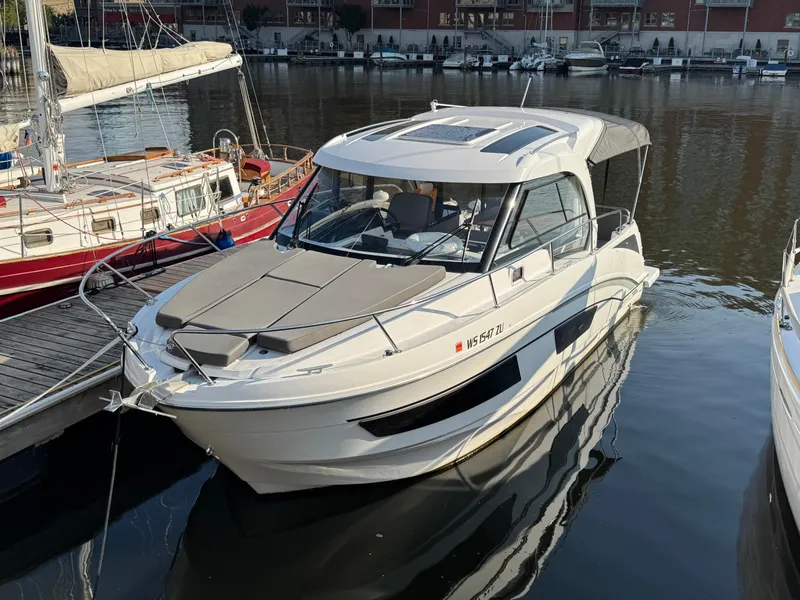 Slide: The Image of 2023 Beneteau Antares 9 boat docked in a marina. - 0