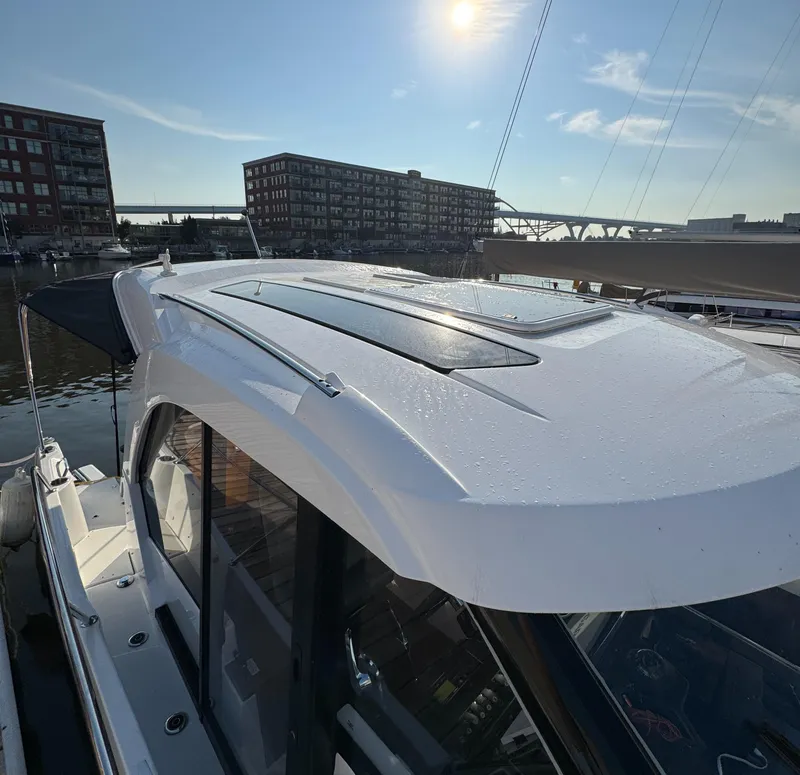 Slide: The Image of 2023 Beneteau Antares 9 boat docked in sunny marina, cityscape background. - 11
