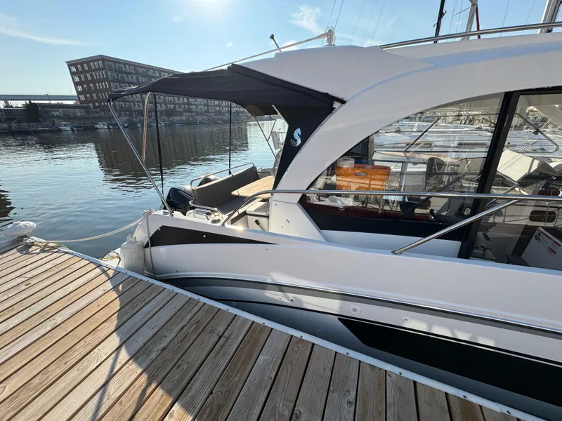 Slide: The Image of 2023 Beneteau Antares 9 docked at marina, sunny day, modern design. - 13