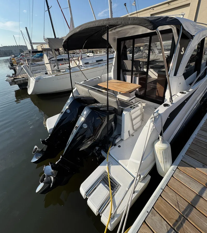 Slide: The Image of 2023 Beneteau Antares 9 boat docked with twin outboard engines. - 14