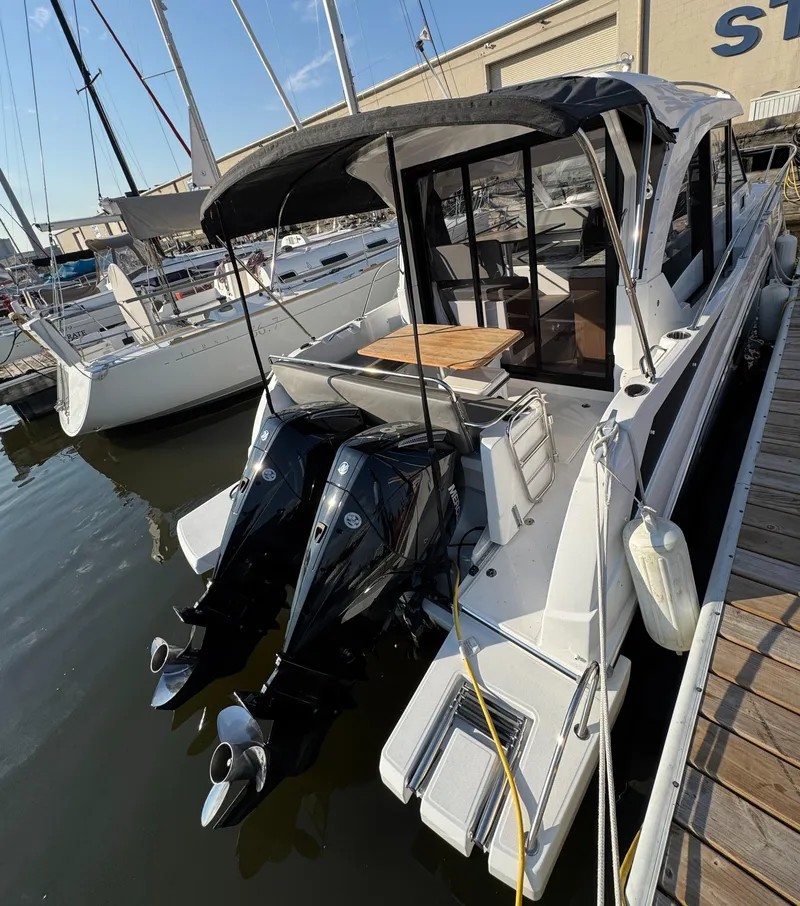 Slide: The Image of 2023 Beneteau Antares 9 boat docked with twin outboard engines. - 15