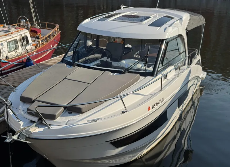 Slide: The Image of 2023 Beneteau Antares 9 boat docked in a marina. - 2