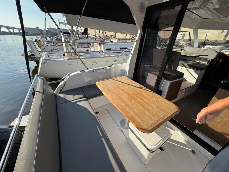 Slide: The Image of 2023 Beneteau Antares 9 boat interior with seating and wooden table, docked at marina. - 21