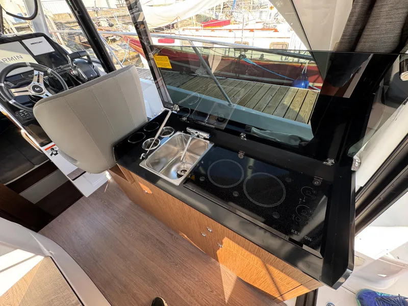 Slide: The Image of Interior of 2023 Beneteau Antares 9 boat with modern kitchen and steering area. - 27