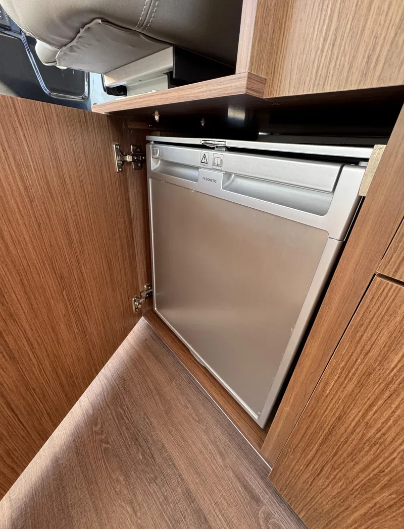 Slide: The Image of Compact fridge in 2023 Beneteau Antares 9 boat interior, wooden cabinetry. - 28
