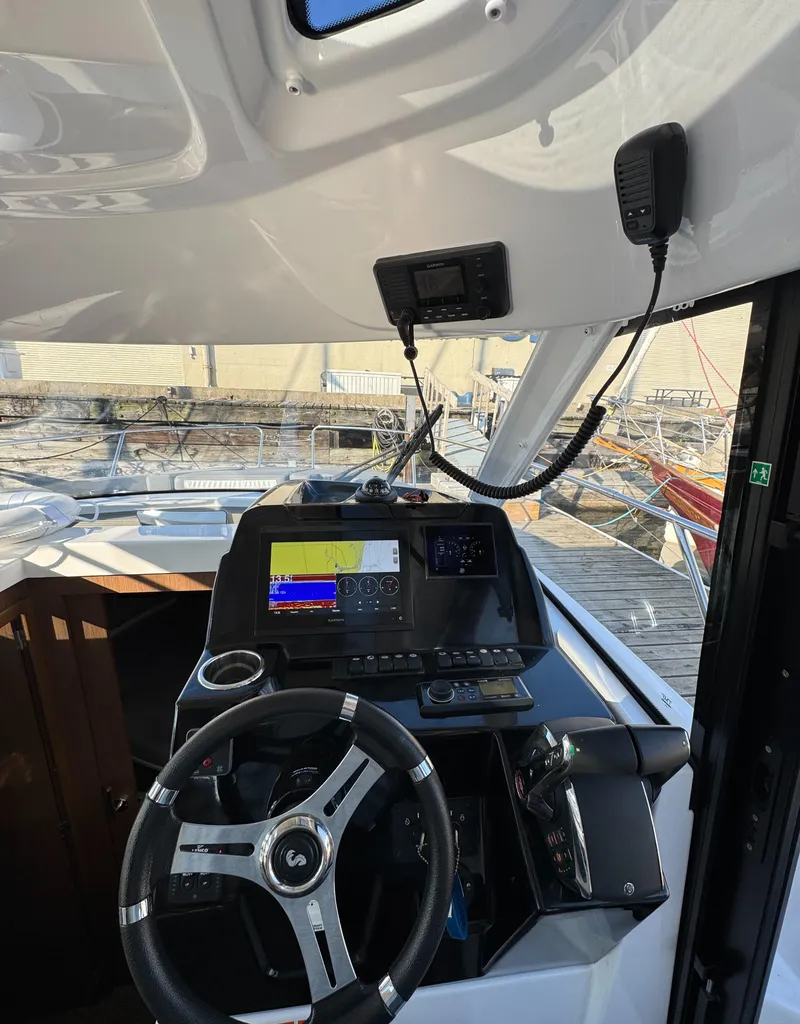 Slide: The Image of 2023 Beneteau Antares 9 helm with modern navigation equipment and steering wheel. - 41