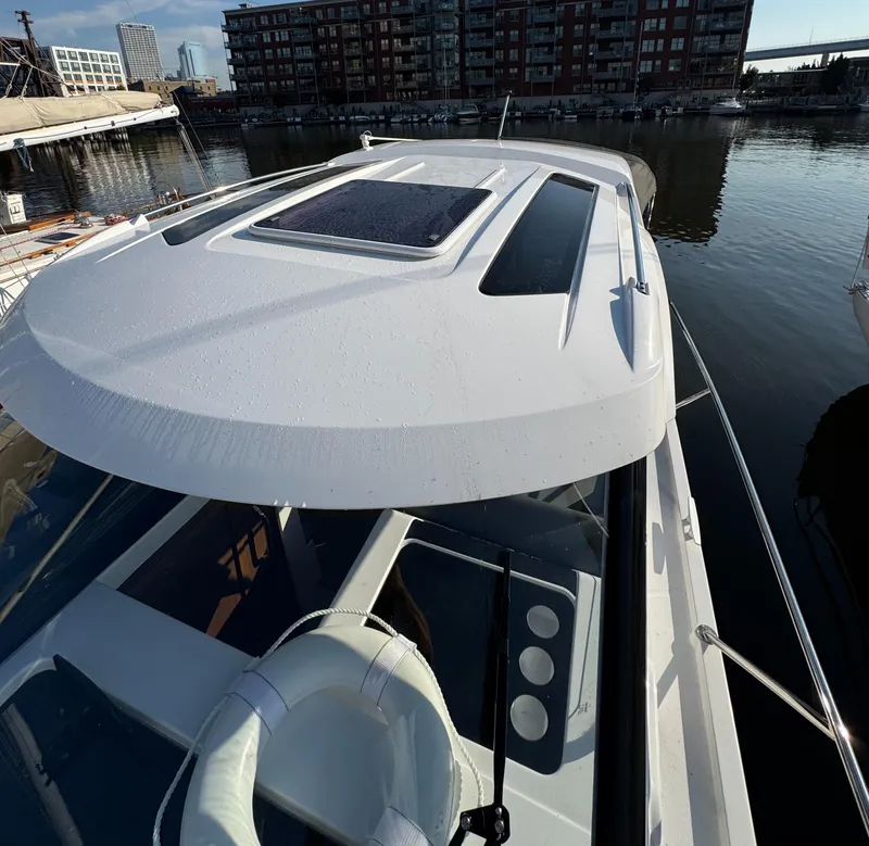 Slide: The Image of 2023 Beneteau Antares 9 boat docked in urban marina setting. - 5