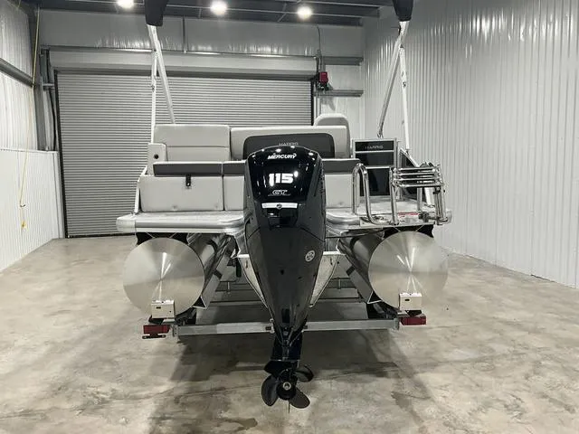 Slide: The Image of 2025 Harris Cruiser 210 SL pontoon boat with Mercury 115 engine in a storage facility. - 3