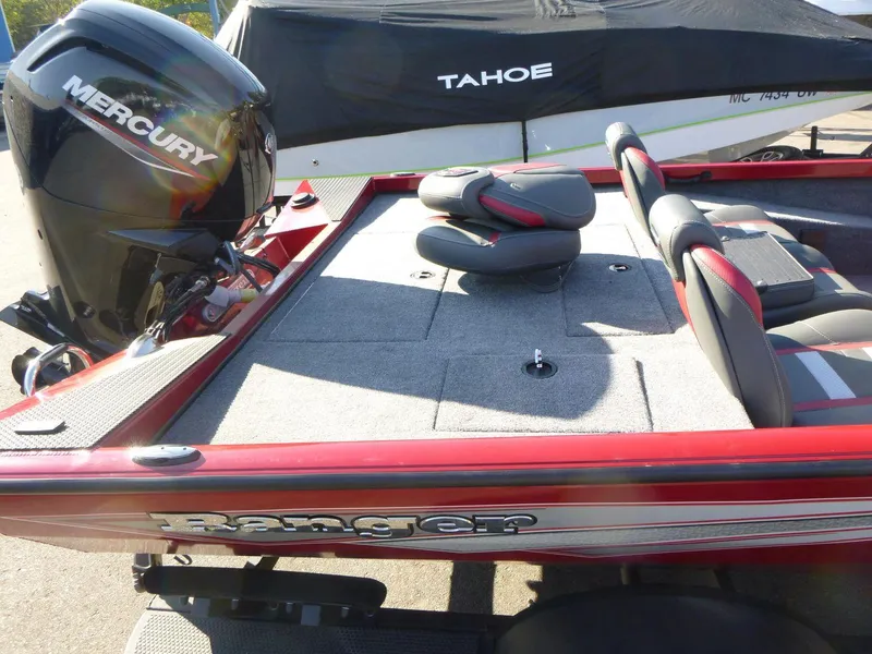 Slide: The Image of 2024 Ranger RT188 boat with Mercury engine, red and gray seating, parked near Tahoe boat. - 5