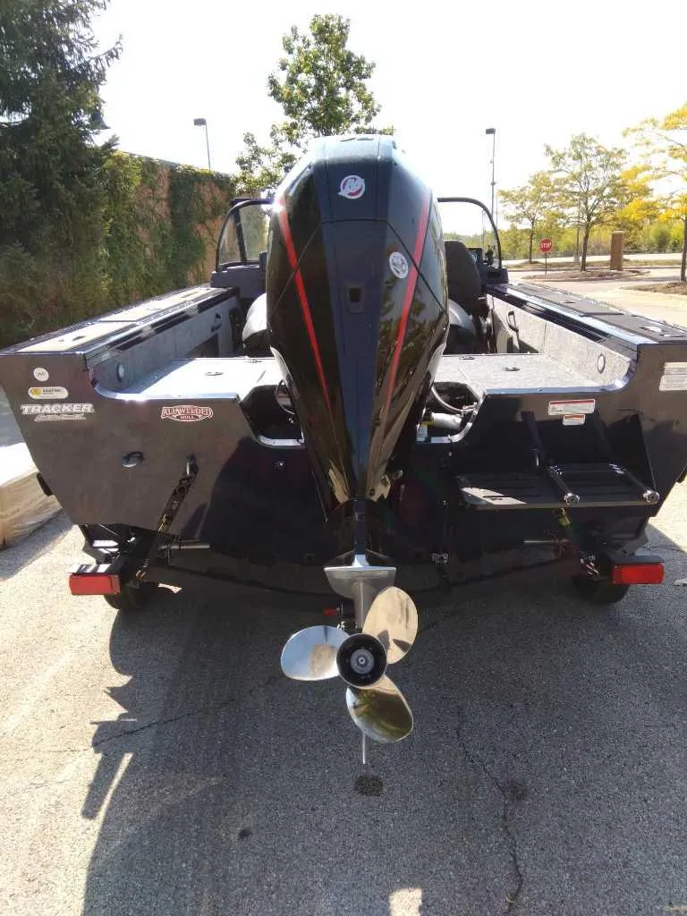 Slide: The Image of 2025 Tracker Targa V-18 WT boat, rear view with outboard motor, parked outdoors. - 4