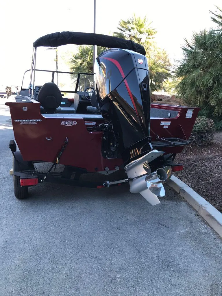 Slide: The Image of 2025 Tracker Targa V-18 Combo boat with powerful outboard motor, parked on a sunny day. - 9