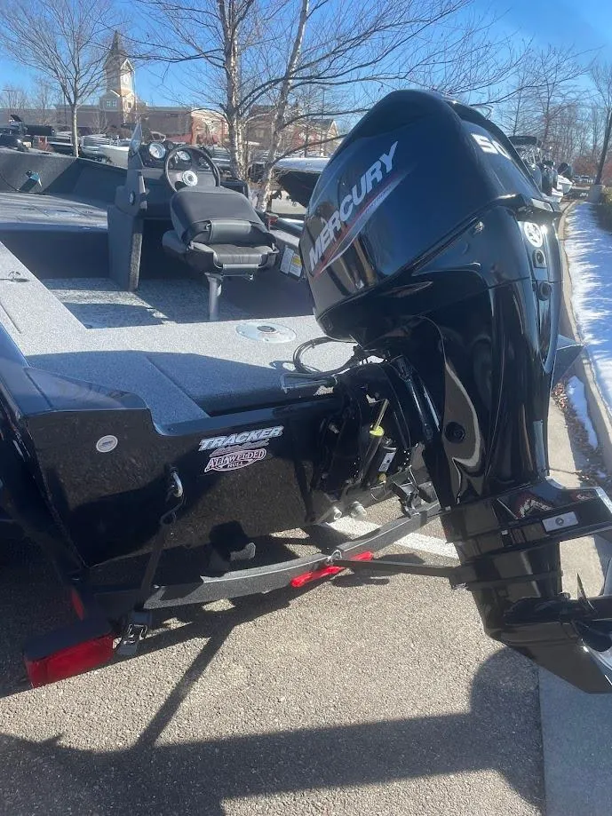 Slide: The Image of 2025 Tracker Super Guide V-16 SC boat with Mercury outboard motor, parked outdoors. - 3