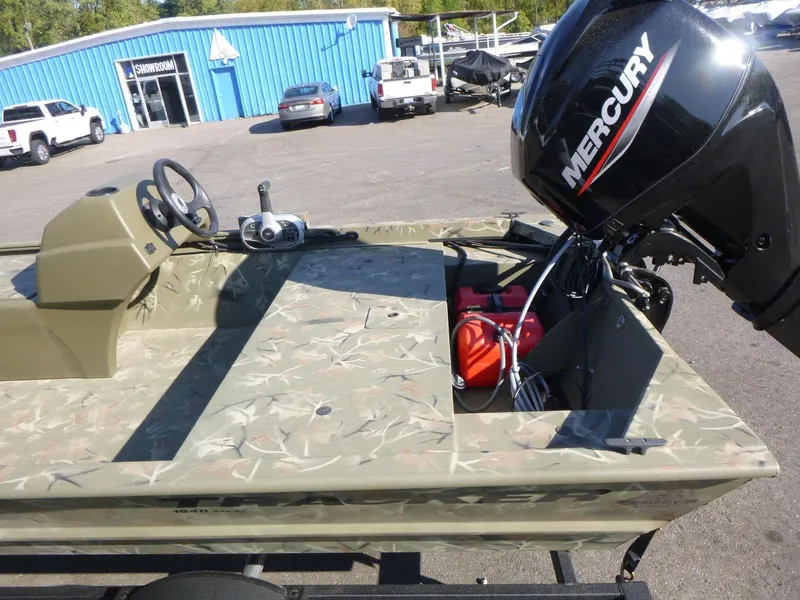 Slide: The Image of 2024 Tracker Grizzly 1648 SC boat with Mercury outboard motor in dealership lot. - 14