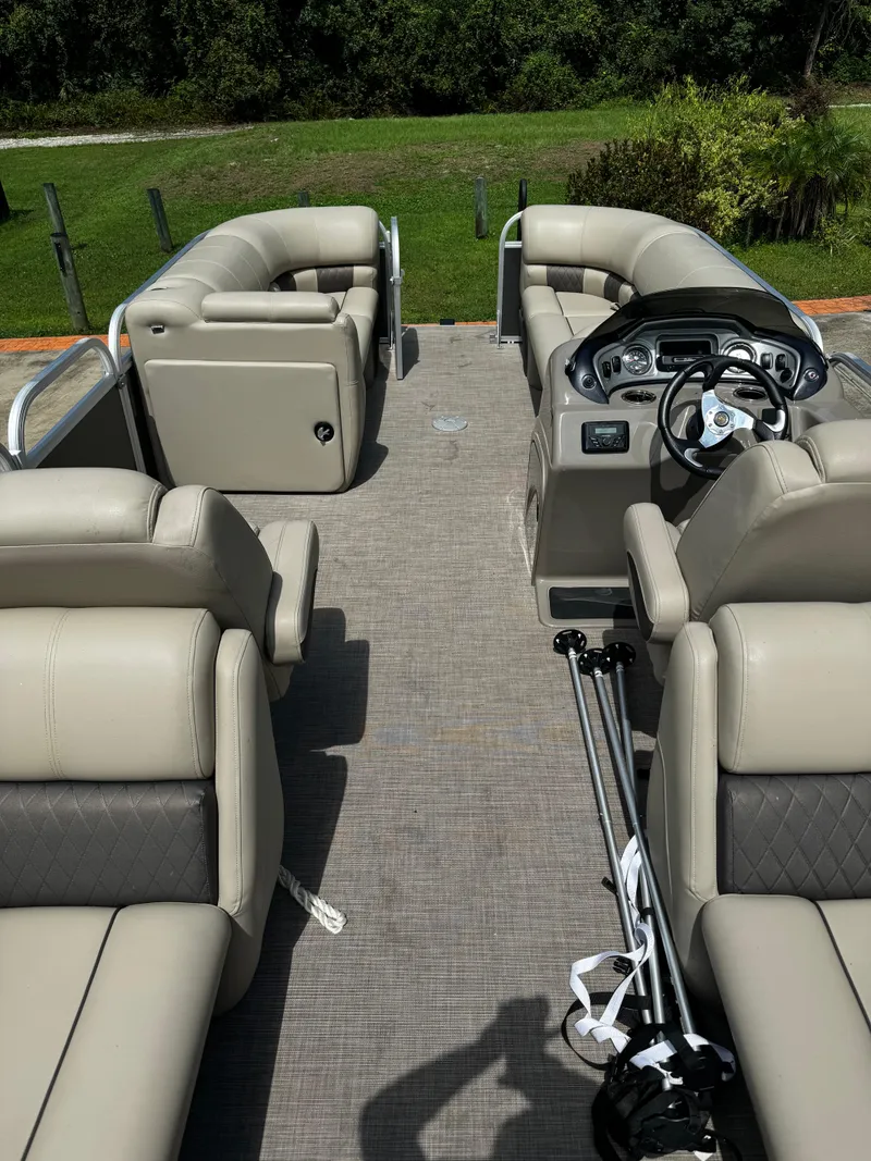 Slide: The Image of 2023 Sun Tracker Party Barge 22 DLX interior with plush seating and steering console. - 11