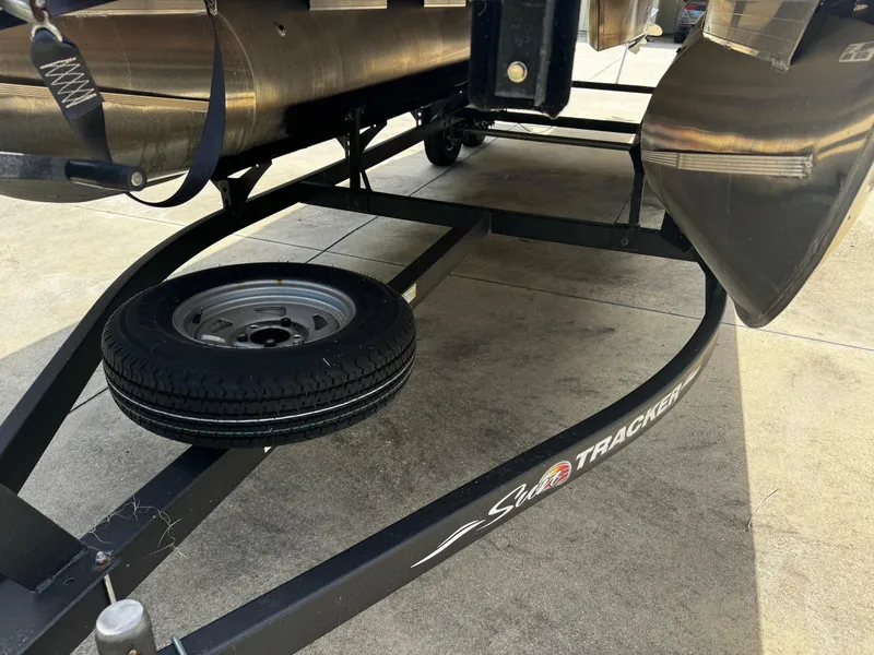Slide: The Image of 2023 Sun Tracker Party Barge 22 DLX trailer with spare tire on concrete surface. - 15