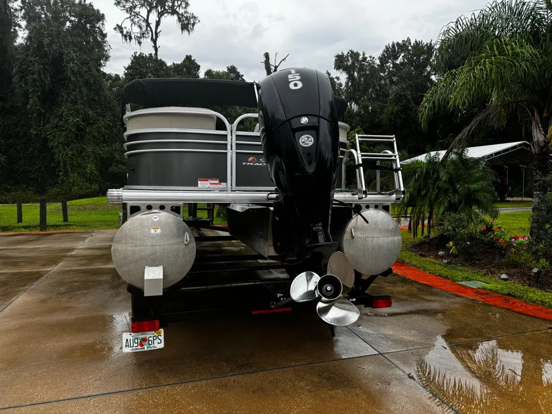 Slide: The Image of 2023 Sun Tracker Party Barge 22 DLX pontoon boat on a wet driveway. - 24