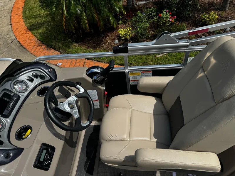 Slide: The Image of 2023 Sun Tracker Party Barge 22 DLX helm with beige captain's chair and steering wheel. - 3