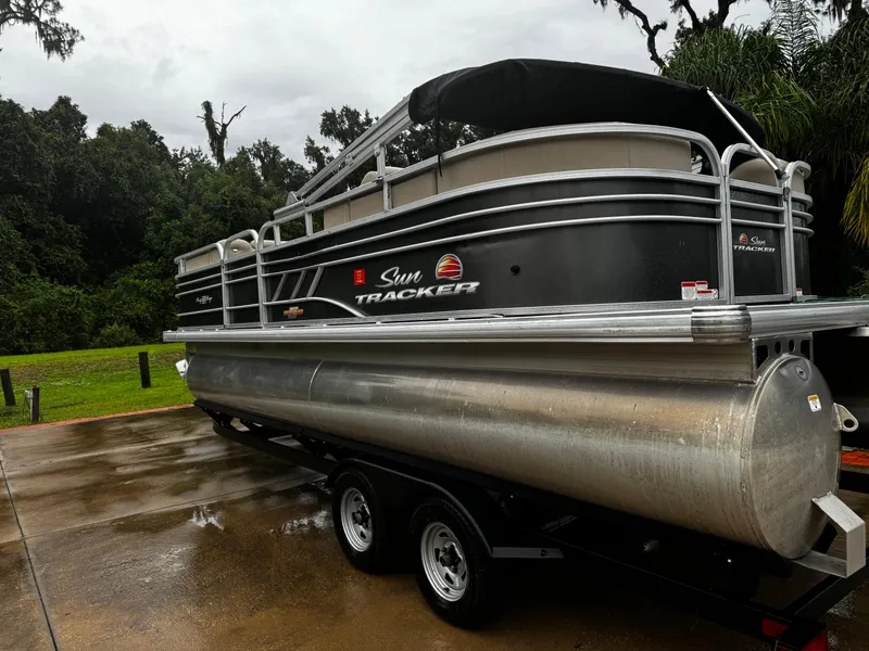 Slide: The Image of 2023 Sun Tracker Party Barge 22 DLX pontoon boat on trailer, parked outdoors. - 7