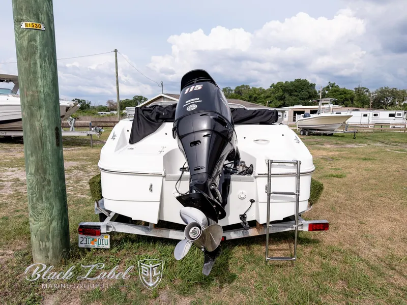 Slide: The Image of 2015 Caravelle 19 EBO boat with outboard motor on trailer, parked outdoors. - 3