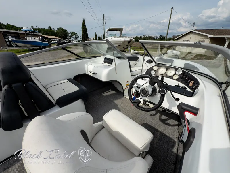 Slide: The Image of Interior of a 2015 Caravelle 19 EBO boat with steering wheel and seating. - 6