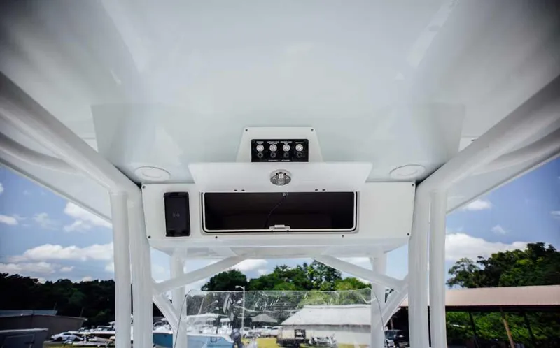 Slide: The Image of 2021 Sea Fox 248 Commander boat console with storage and controls, under a clear blue sky. - 24