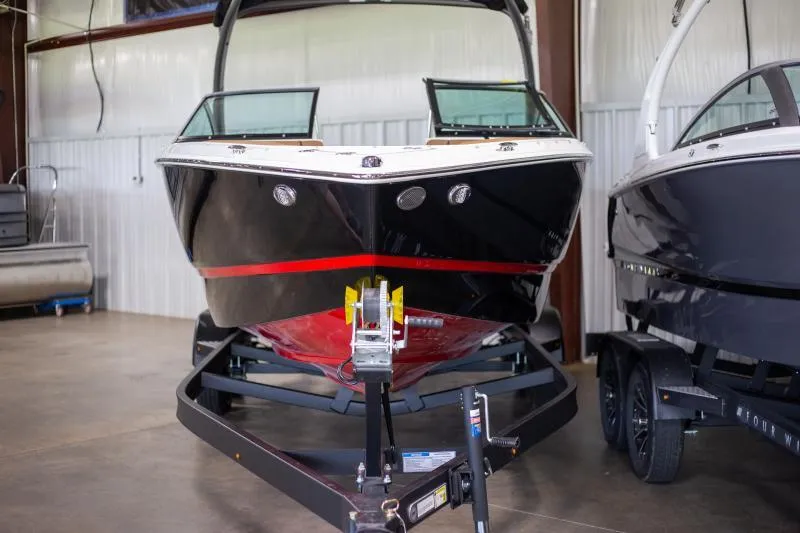 Slide: The Image of 2025 Four Winns H4 boat in showroom, black and red design, on trailer. - 4