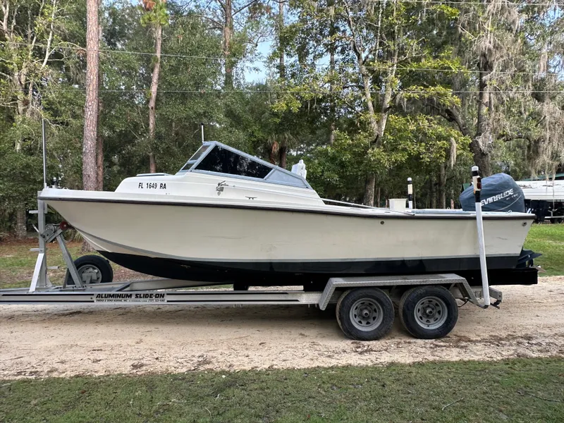 Slide: The Image of 1987 Mako 228 boat on trailer in wooded area. - 1