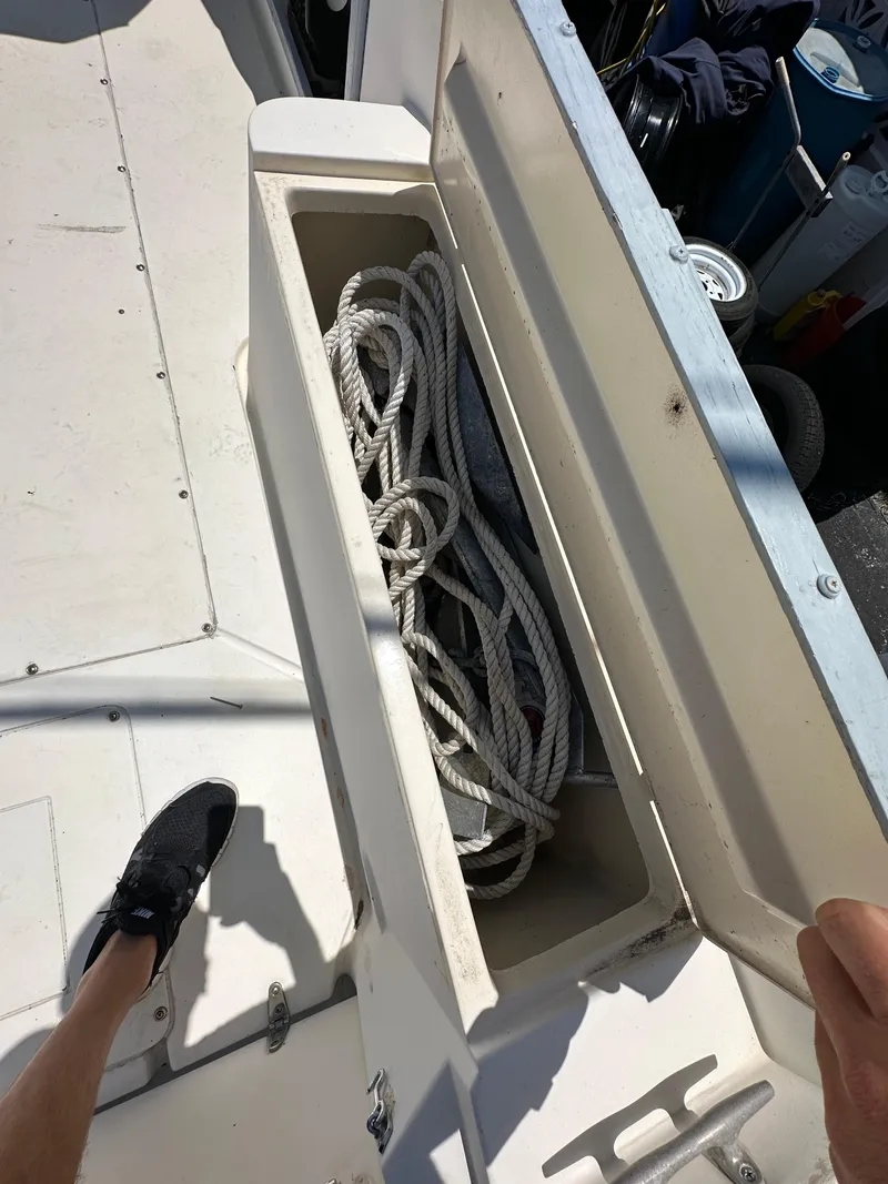 Slide: The Image of Open storage compartment on 1987 Mako 228 boat with coiled rope inside. - 15