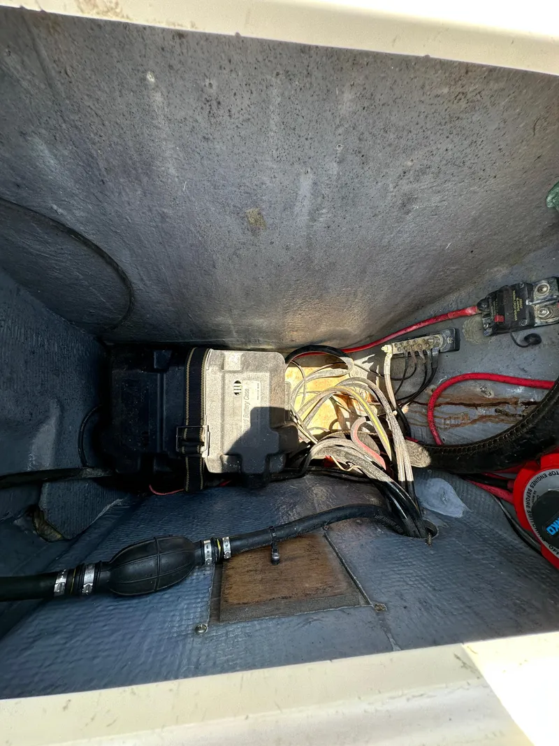 Slide: The Image of 1987 Mako 228 boat battery compartment with wiring and components. - 17